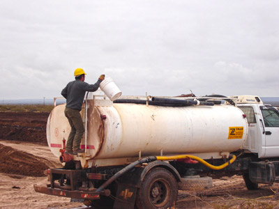 Carga y dilución de la solución conteniendo microorganismos en el camión tanque que va a esparcir sobre el suelo contaminado